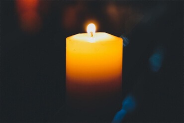 Lit candle in dark room